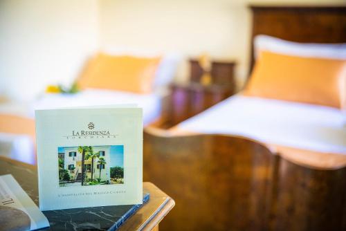a book on a table next to a bed at B&B La Residenza Torchiara in Torchiara
