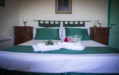 a bed with two towels and flowers on it at B&B La Residenza Torchiara in Torchiara