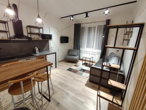 a kitchen and living room with a table and chairs at Loft возле парка, стадиона и озера in Ivano-Frankivsʼk