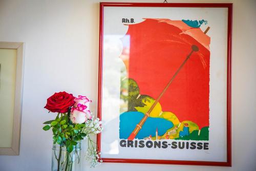 a framed picture of an umbrella on a wall with a vase of flowers at B&B La Residenza Torchiara in Torchiara