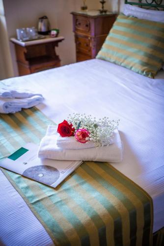 a bed with two roses and a knife on it at B&B La Residenza Torchiara in Torchiara