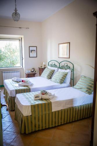 two twin beds in a bedroom with a window at B&B La Residenza Torchiara in Torchiara