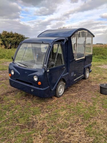 a small blue van parked in a field at Glamping with Llamas in Wisbech