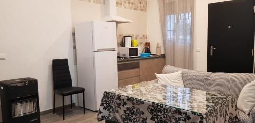 cocina con sofá, mesa y nevera en Casa Marta, en Setenil