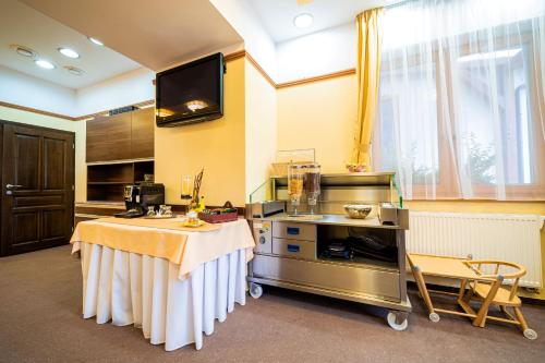 a large kitchen with a table and a tv at Penzion Kiska Kežmarok in Kežmarok