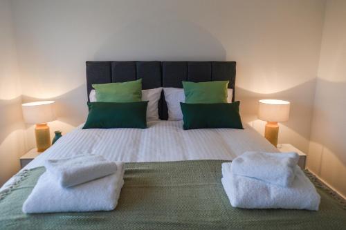 a bedroom with a large bed with two towels on it at Anstey Heights Apartments in Bristol