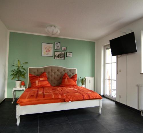 una camera con un letto arancione con una parete verde di Apartment / Flat / Wohnung im Herzen von Dresden a Dresda