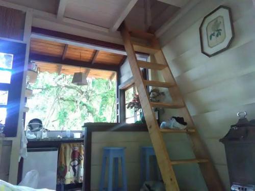 um quarto com uma escada na parede ao lado de uma janela em Chales Bamboo Jungle em Petrópolis