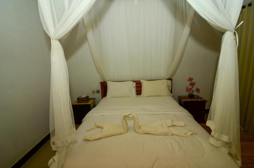 a bedroom with a bed with white drapes at Bintang House in Kintamani