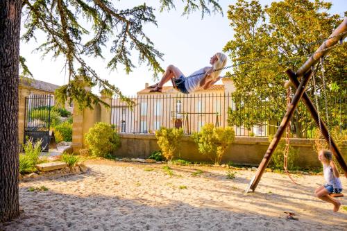 a man playing on a swing with a child at Domaine de Puychêne in Saint-Nazaire-dʼAude