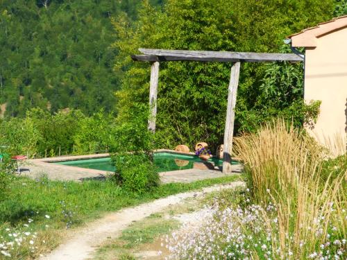 サンタ・フィオーラにあるPodere di Maggio - Seccatoioの庭園のスイミングプールのそばに横たわる子供2名