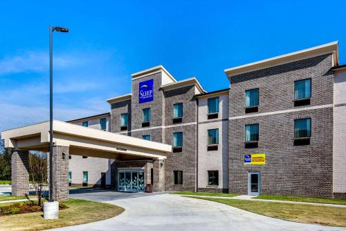 a large brick building with a blue sign on it at Sleep Inn & Suites Gallatin - Nashville Metro in Gallatin