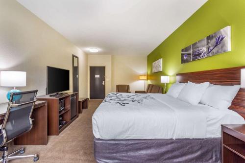 a hotel room with a bed and a flat screen tv at Sleep Inn & Suites Gallatin - Nashville Metro in Gallatin