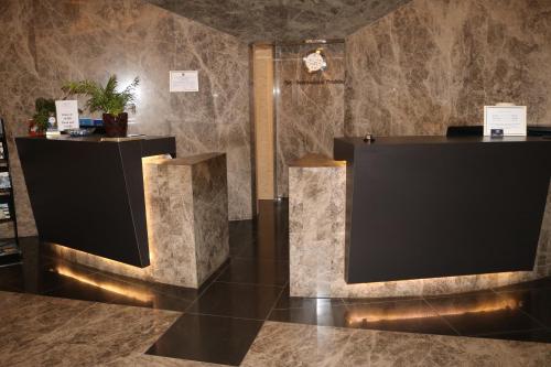 a lobby with a reception desk and marble walls at Hotel International Prishtina & Spa in Pristina