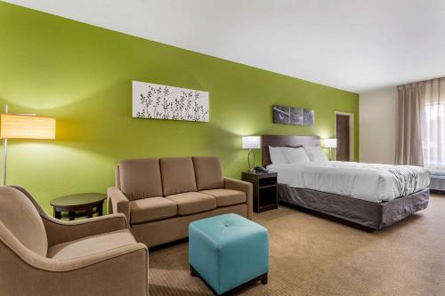 a bedroom with green walls and a bed and chairs at Sleep Inn & Suites Gallatin - Nashville Metro in Gallatin
