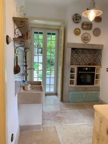 a kitchen with a sink and a fireplace at Entire House - Romantic Vintage Cottage in Sintra