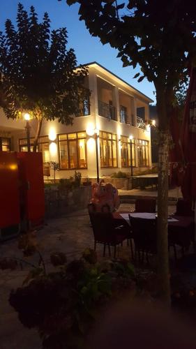 a building with a table and chairs in front of it at Villa Bunski biser in Blagaj