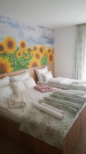 three beds in a room with a painting on the wall at Villa Bunski biser in Blagaj