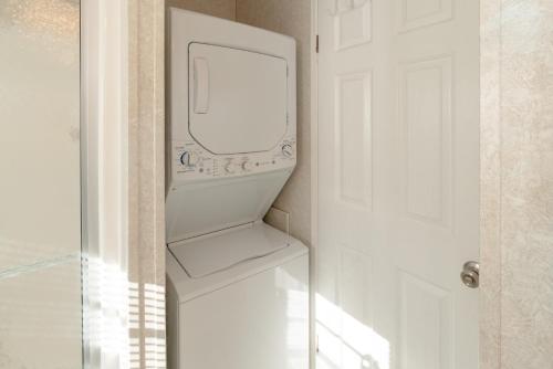 a white washing machine in a bathroom next to a door at Buttonwood Bay in Sebring