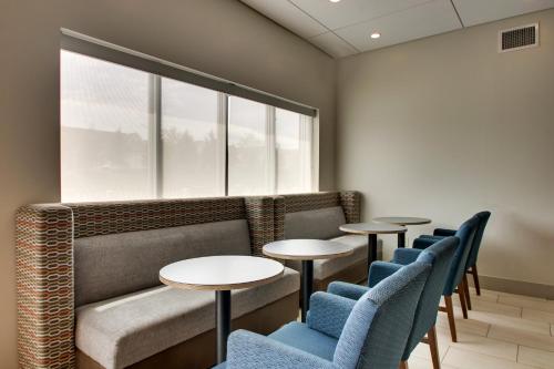 a waiting room with tables and chairs and a window at Holiday Inn Express & Suites Lancaster East - Strasburg by IHG in Strasburg