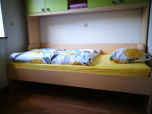 a bed with two pillows sitting on top of it at Apartma Teloh in Kopačnica