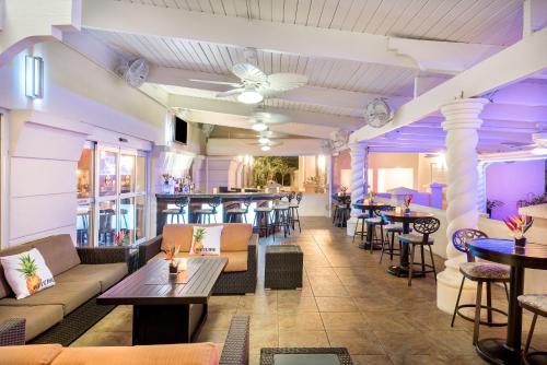 a restaurant with couches and tables and a bar at Holiday Inn Fort Lauderdale Airport by IHG in Hollywood