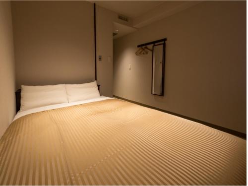 a small room with a bed in the corner at THE HOTELS HAKATA KASANE Bayside in Fukuoka