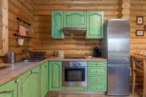a kitchen with green cabinets and a stainless steel refrigerator at Mountain family home Nola Ivano in Delnice