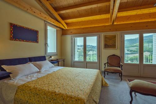 a bedroom with a bed in a room with windows at Appartamento San Pietro in Arcevia