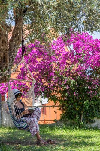 a woman sitting in a hammock in front of a tree at Victoria Hill Hotel in Dassia
