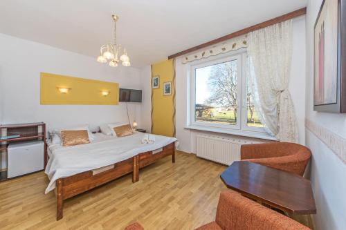 a bedroom with a bed and a large window at Lawendowy Zakątek - przytulne pokoje i pyszne śniadania in Łeba