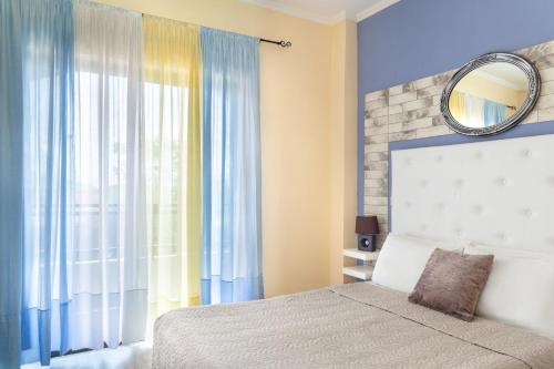 a bedroom with a bed with a mirror and a window at Victoria Hill Hotel in Dassia