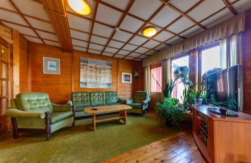 a waiting room with a couch and chairs and a tv at Padu Hotell in Kärdla