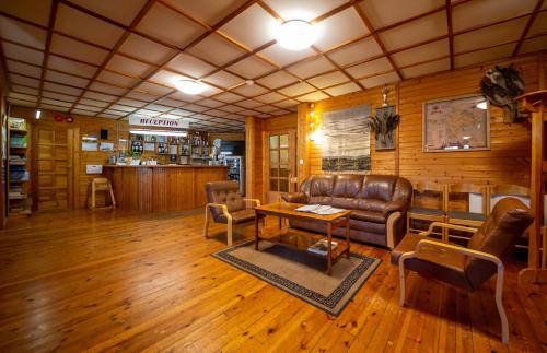 a living room with a leather couch and a table at Padu Hotell in Kärdla