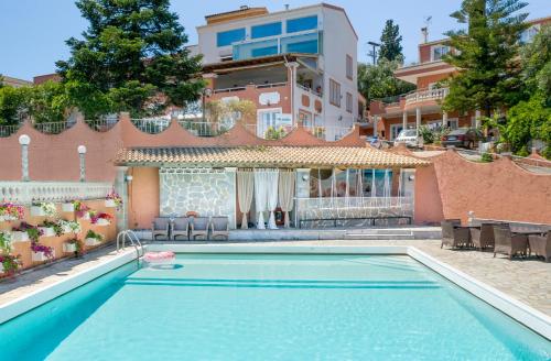 a swimming pool in front of a building at Victoria Hill Hotel in Dassia