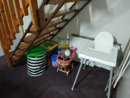 a doll house with a staircase and a table and a chair at Chata Babeta in Poniklá