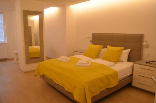 um quarto com uma cama com lençóis amarelos e um espelho em "Strandläufer" Villa Odin em Ostseebad Sellin