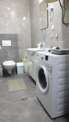 Apartments in city center في كومانوفو: حمام مع غسالة ومغسلة