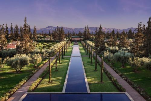 a pathway through a garden with trees and grass at The Oberoi Marrakech in Marrakech
