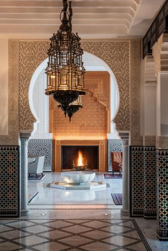 a large lobby with a fireplace and a chandelier at The Oberoi Marrakech in Marrakech