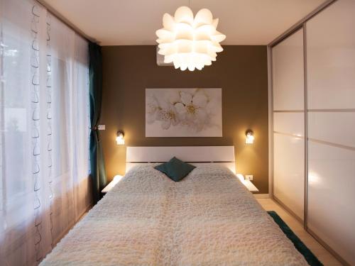 a bedroom with a large bed and a chandelier at Feels Like Home Apartments in Zagreb