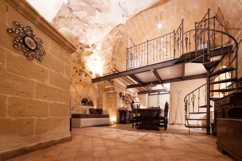 Une grande chambre avec un escalier se trouve dans un bâtiment. dans l'établissement Casa Masiello La casa tipica dei Sassi di Matera, à Matera