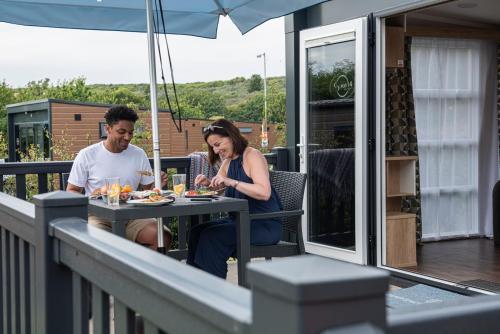 een man en vrouw aan een tafel op een balkon bij Brighton Experience Freedom Glamping in Brighton & Hove