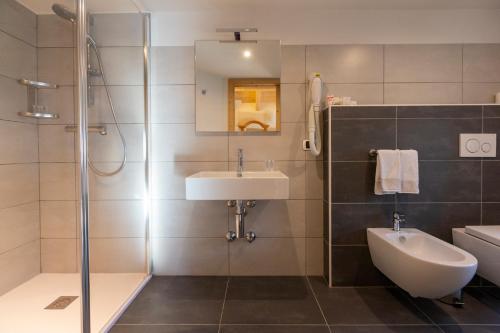 W łazience znajduje się umywalka i prysznic. w obiekcie Hotel "La Suisse" w Livigno