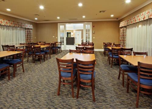 a dining room with wooden tables and chairs at Holiday Inn Express Corning by IHG in Corning