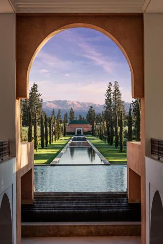 an archway leading to a pool in a garden at The Oberoi Marrakech in Marrakech