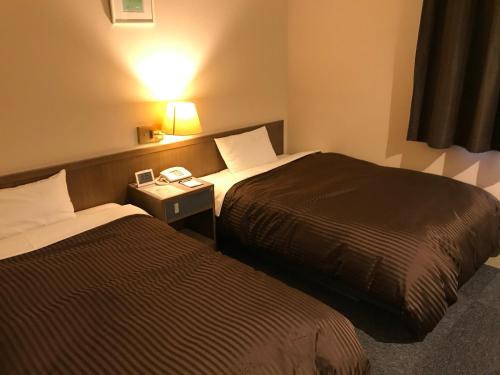 Ένα ή περισσότερα κρεβάτια σε δωμάτιο στο Hotel Avan Sukumo