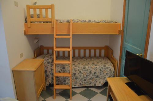a bedroom with two bunk beds and a television at Guardia dei Mori in Carloforte