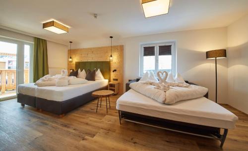 a hotel room with two beds in a room at Hotel Hubertushof in Saalbach Hinterglemm