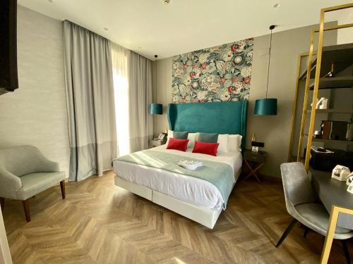 a bedroom with a large bed and a chair at Soho Boutique Sevilla in Seville